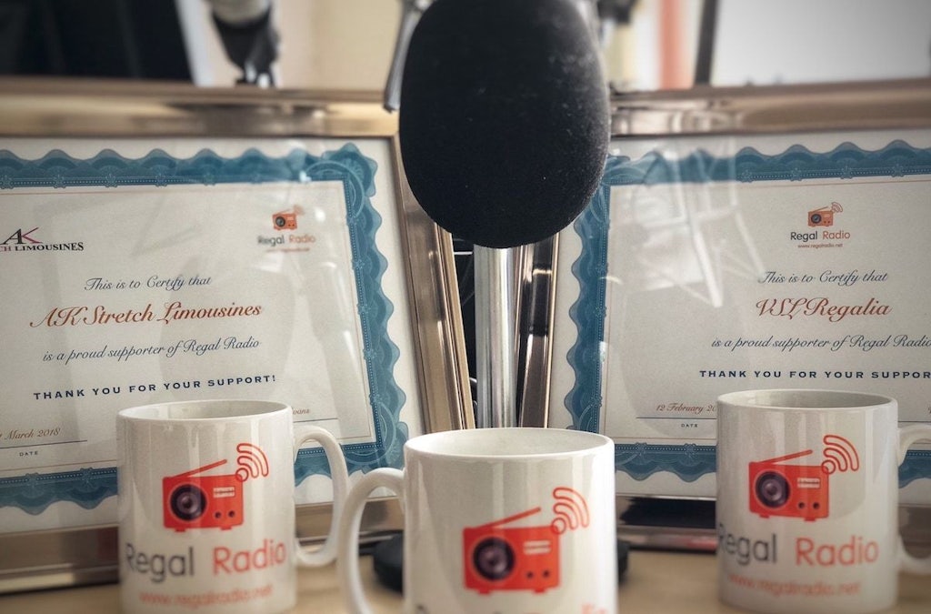 Two, framed certificates of Regal Radio sponsorship, surrounded by a microphone and Regal Radio mugs.
